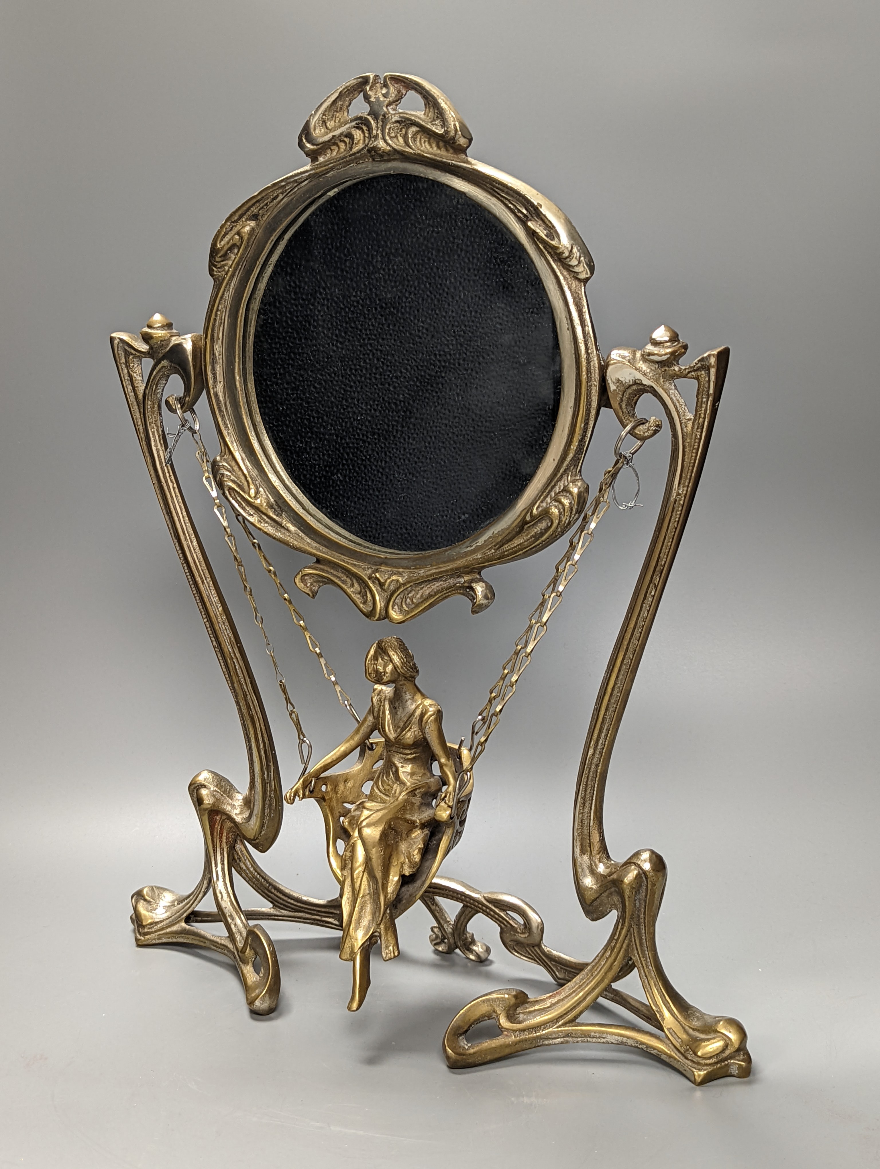 An Art Nouveau style mirror with model of girl sitting on a swing, height 45cm